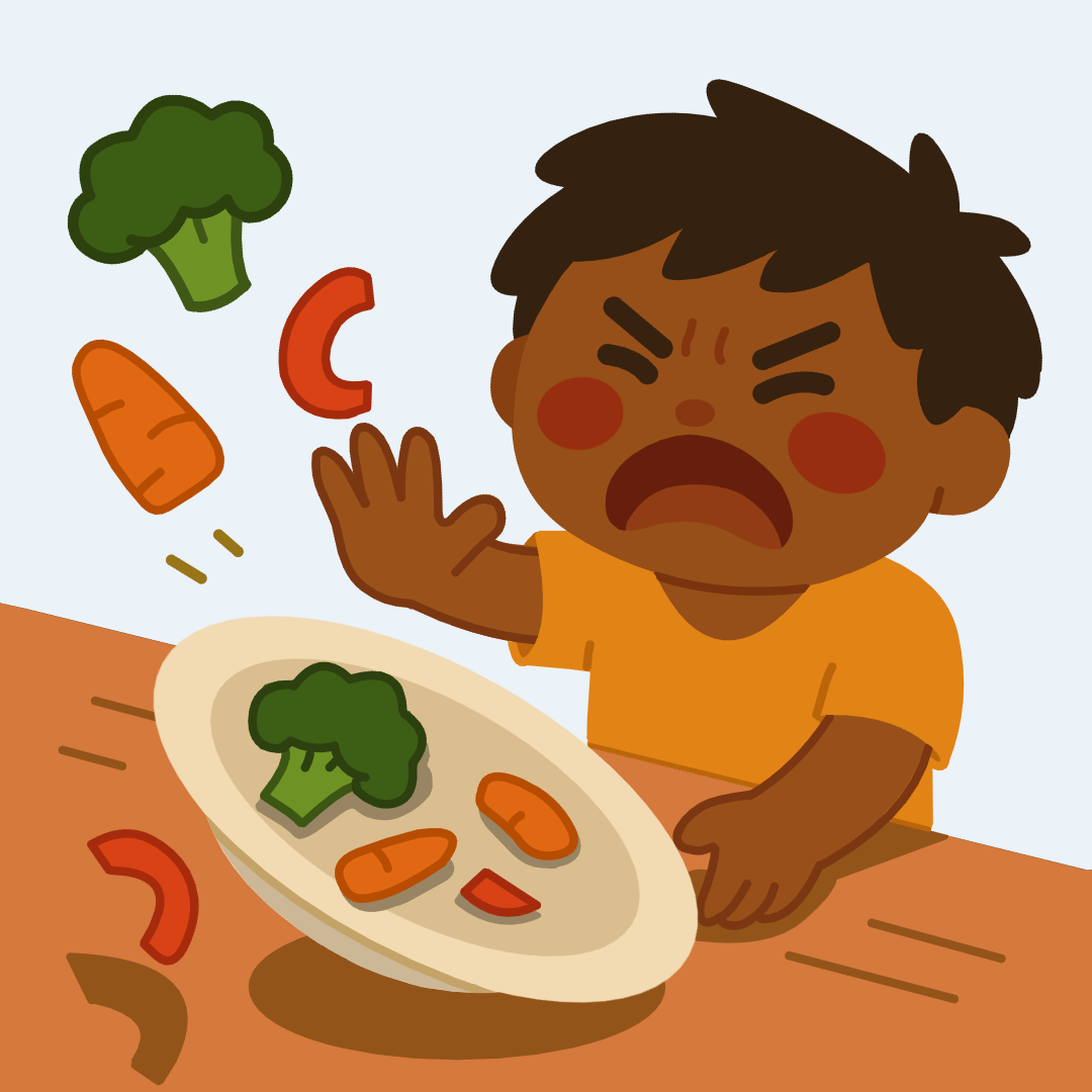 Een kind gooit boos zijn bord met groenten van tafel.